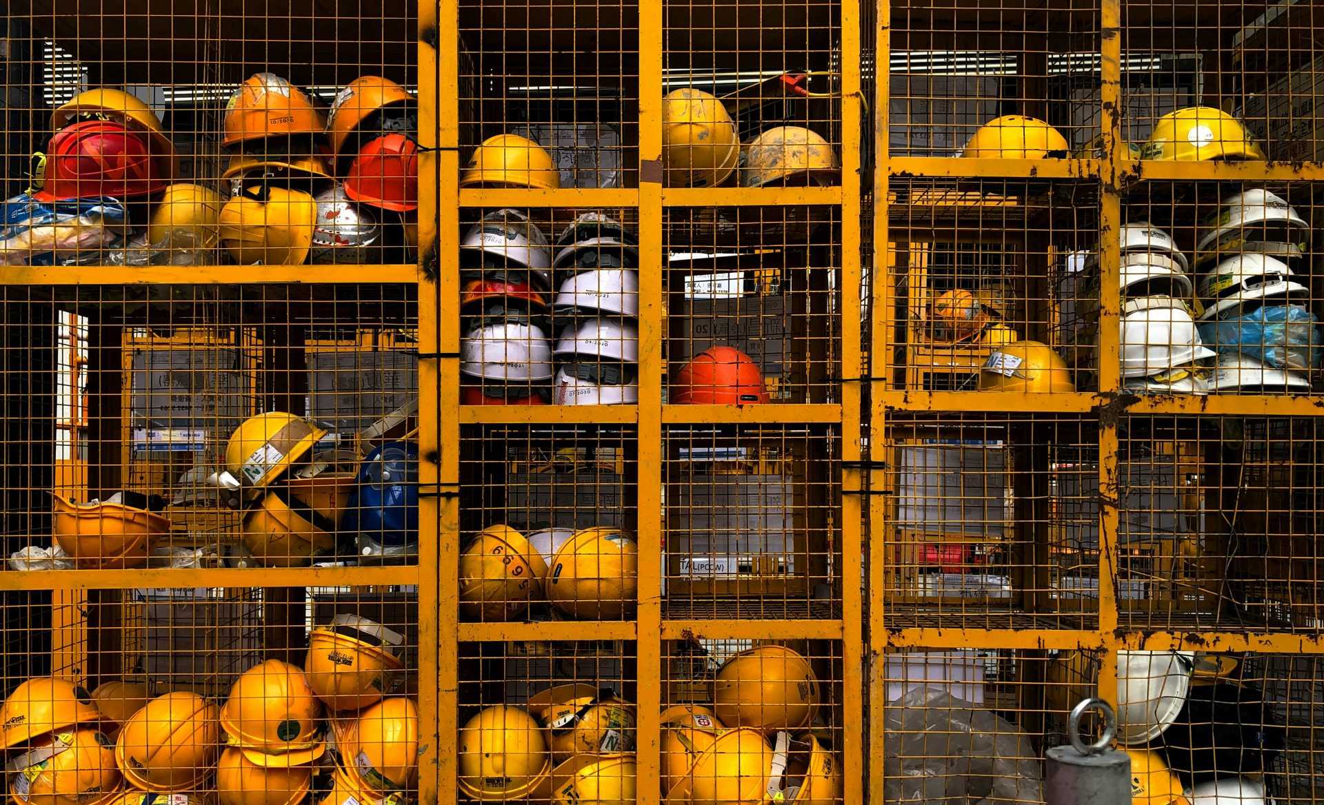 a rack filled with lots of yellow hard hats